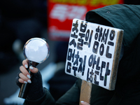 A university student protests in Yeouido, Seoul, South Korea, on December 8, 2024, across from the National Assembly, holding a sign that re...