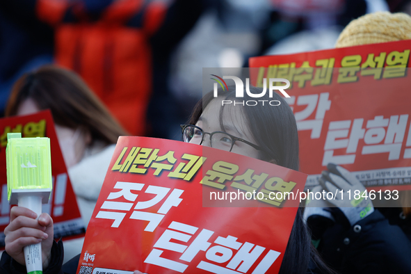 Tens of thousands of citizens gather across from the National Assembly in Yeouido, Seoul, South Korea, on December 8, 2024, holding signs th...