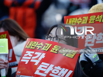 Tens of thousands of citizens gather across from the National Assembly in Yeouido, Seoul, South Korea, on December 8, 2024, holding signs th...