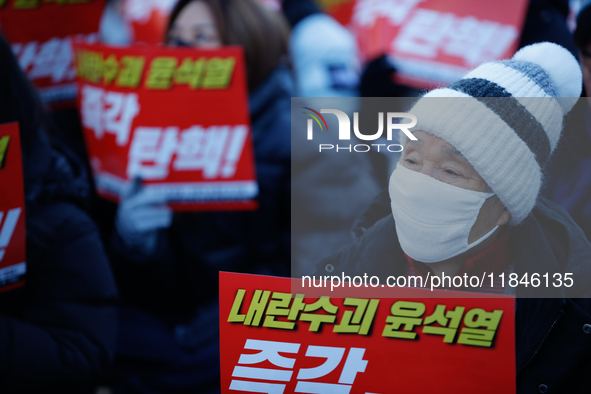 Tens of thousands of citizens gather across from the National Assembly in Yeouido, Seoul, South Korea, on December 8, 2024, holding signs th...