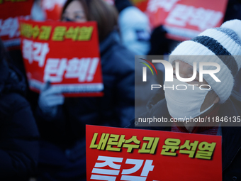 Tens of thousands of citizens gather across from the National Assembly in Yeouido, Seoul, South Korea, on December 8, 2024, holding signs th...