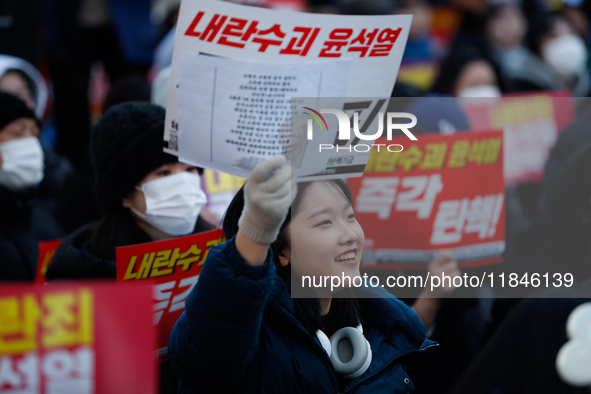 Tens of thousands of citizens gather across from the National Assembly in Yeouido, Seoul, South Korea, on December 8, 2024, holding signs th...