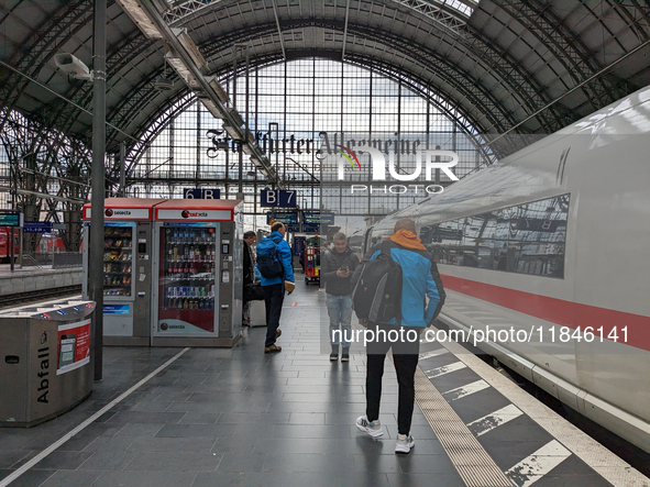 Travelers prepare for departure alongside an ICE train. On March 30, 2023, travelers are on Platform 6B at Frankfurt am Main Central Station...