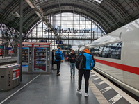 Travelers prepare for departure alongside an ICE train. On March 30, 2023, travelers are on Platform 6B at Frankfurt am Main Central Station...