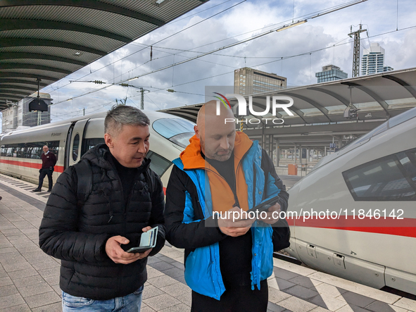 Two passengers check information at the platform in Frankfurt am Main, Hesse, Germany, on March 30, 2023. Two travelers stand on the platfor...