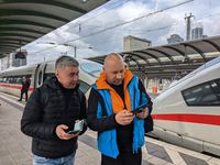 Two passengers check information at the platform in Frankfurt am Main, Hesse, Germany, on March 30, 2023. Two travelers stand on the platfor...