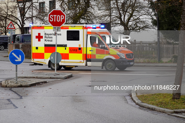 A Bavarian Red Cross ambulance with flashing blue lights is on a mission in Gauting, Bavaria, Germany, on December 8, 2024. 