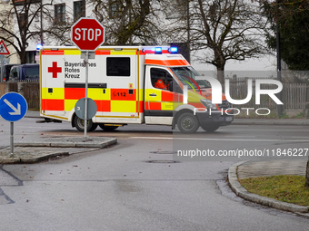 A Bavarian Red Cross ambulance with flashing blue lights is on a mission in Gauting, Bavaria, Germany, on December 8, 2024. (