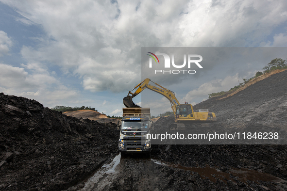 A mining vehicle loads coal material into a truck at an opencast coalmine in South Kalimantan, Indonesia, on December 8, 2024. Environmental...