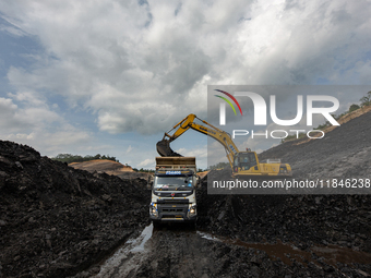 A mining vehicle loads coal material into a truck at an opencast coalmine in South Kalimantan, Indonesia, on December 8, 2024. Environmental...