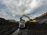 A mining vehicle loads coal material into a truck at an opencast coalmine in South Kalimantan, Indonesia, on December 8, 2024. Environmental...