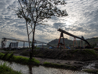 A conveyor belt and piles of coal are at a stockpile in Kalimantan, Indonesia, on December 8, 2024. Environmental activists express concern...