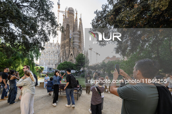 People gather in a park near the cathedral of the Sagrada Familia in Barcelona, Spain, on October 09, 2024. This monument, designed by archi...