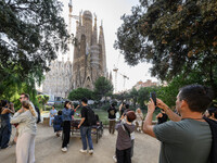 People gather in a park near the cathedral of the Sagrada Familia in Barcelona, Spain, on October 09, 2024. This monument, designed by archi...