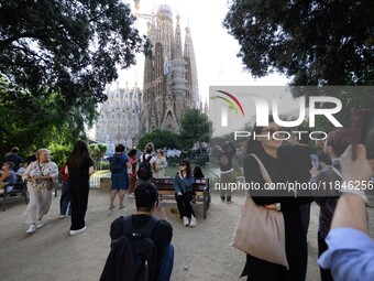 People gather in a park near the cathedral of the Sagrada Familia in Barcelona, Spain, on October 09, 2024. This monument, designed by archi...