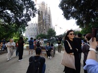 People gather in a park near the cathedral of the Sagrada Familia in Barcelona, Spain, on October 09, 2024. This monument, designed by archi...