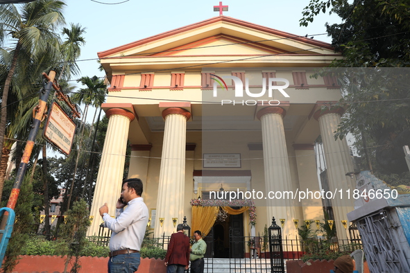 People stand outside before Christians hold a special Mass to celebrate the centenary at India's only Greek Orthodox Church in Kolkata, Indi...