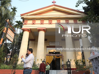 People stand outside before Christians hold a special Mass to celebrate the centenary at India's only Greek Orthodox Church in Kolkata, Indi...