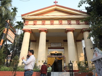 People stand outside before Christians hold a special Mass to celebrate the centenary at India's only Greek Orthodox Church in Kolkata, Indi...