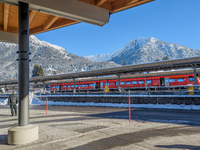 A red regional train stands at the platform at Oberstdorf train station in Schwaben, Oberallgau, Bavaria, Germany, on January 20, 2024, with...