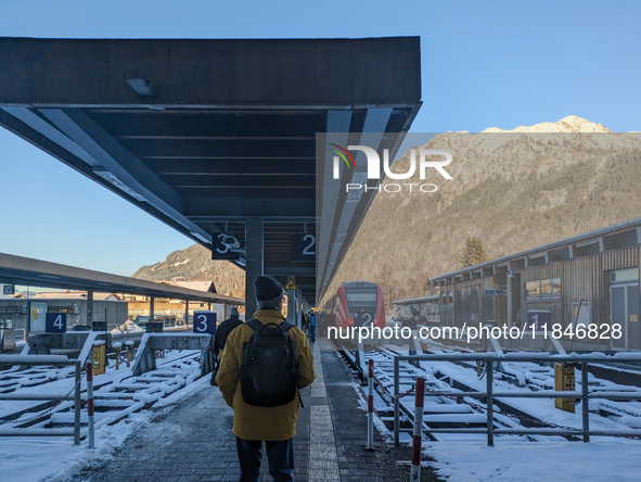 At Oberstdorf train station in Swabia, Upper Allgaeu, Bavaria, Germany, on January 20, 2024, a traveler stands on the snow-covered platform...