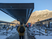 At Oberstdorf train station in Swabia, Upper Allgaeu, Bavaria, Germany, on January 20, 2024, a traveler stands on the snow-covered platform...