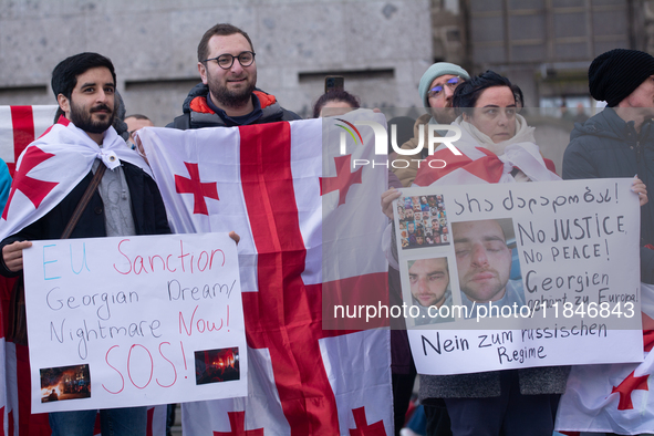 Dozens of people take part in a pro-EU demonstration for Georgia and support the crackdown in Georgia in Cologne, Germany, on December 8, 20...