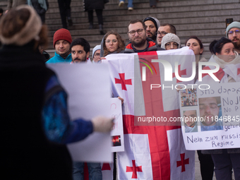 Dozens of people take part in a pro-EU demonstration for Georgia and support the crackdown in Georgia in Cologne, Germany, on December 8, 20...