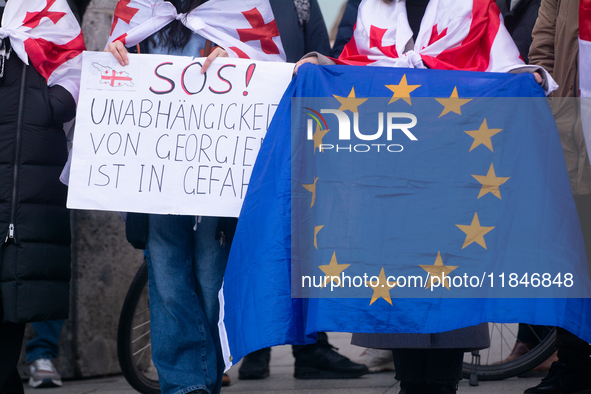 Dozens of people take part in a pro-EU demonstration for Georgia and support the crackdown in Georgia in Cologne, Germany, on December 8, 20...