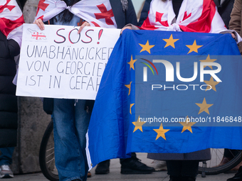 Dozens of people take part in a pro-EU demonstration for Georgia and support the crackdown in Georgia in Cologne, Germany, on December 8, 20...