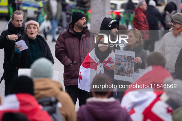 Dozens of people take part in a pro-EU demonstration for Georgia and support the crackdown in Georgia in Cologne, Germany, on December 8, 20...