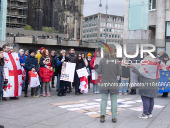 Dozens of people take part in a pro-EU demonstration for Georgia and support the crackdown in Georgia in Cologne, Germany, on December 8, 20...