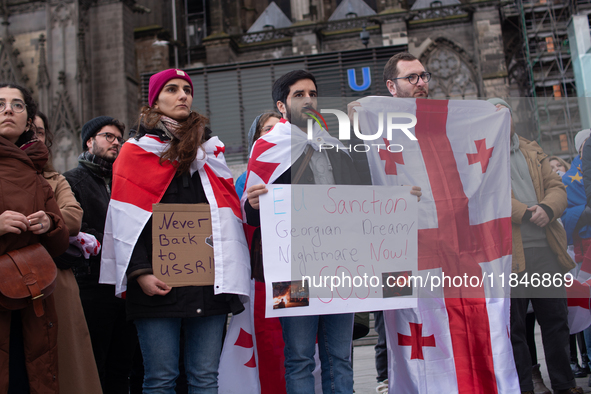 Dozens of people take part in a pro-EU demonstration for Georgia and support the crackdown in Georgia in Cologne, Germany, on December 8, 20...