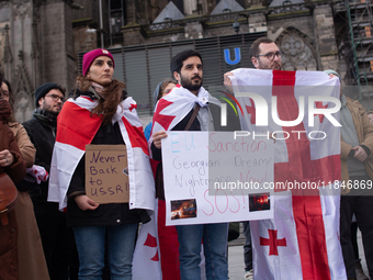 Dozens of people take part in a pro-EU demonstration for Georgia and support the crackdown in Georgia in Cologne, Germany, on December 8, 20...