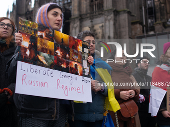 Dozens of people take part in a pro-EU demonstration for Georgia and support the crackdown in Georgia in Cologne, Germany, on December 8, 20...