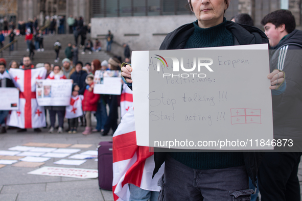 Dozens of people take part in a pro-EU demonstration for Georgia and support the crackdown in Georgia in Cologne, Germany, on December 8, 20...