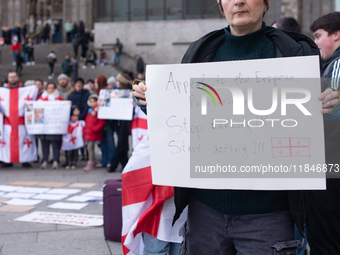 Dozens of people take part in a pro-EU demonstration for Georgia and support the crackdown in Georgia in Cologne, Germany, on December 8, 20...