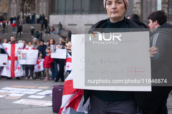 Dozens of people take part in a pro-EU demonstration for Georgia and support the crackdown in Georgia in Cologne, Germany, on December 8, 20...