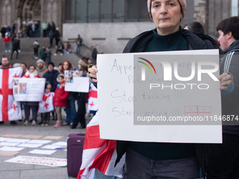 Dozens of people take part in a pro-EU demonstration for Georgia and support the crackdown in Georgia in Cologne, Germany, on December 8, 20...