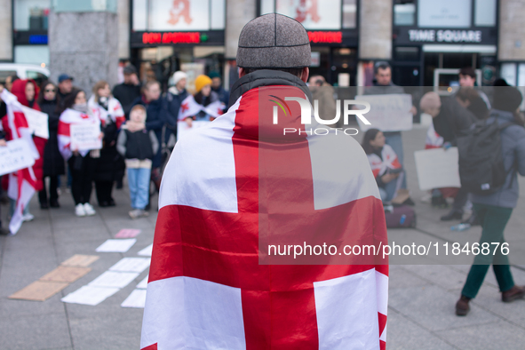 Dozens of people take part in a pro-EU demonstration for Georgia and support the crackdown in Georgia in Cologne, Germany, on December 8, 20...