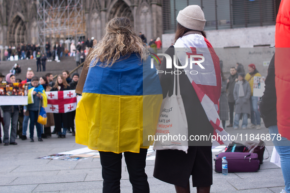 Dozens of people take part in a pro-EU demonstration for Georgia and support the crackdown in Georgia in Cologne, Germany, on December 8, 20...