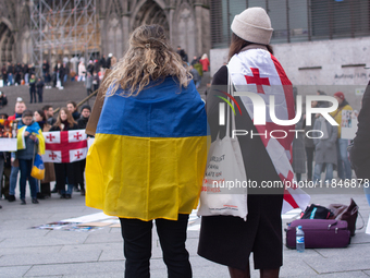 Dozens of people take part in a pro-EU demonstration for Georgia and support the crackdown in Georgia in Cologne, Germany, on December 8, 20...