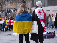 Dozens of people take part in a pro-EU demonstration for Georgia and support the crackdown in Georgia in Cologne, Germany, on December 8, 20...