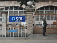 A person stands next to an SBI bank branch in Kolkata, India, on December 8, 2024. (