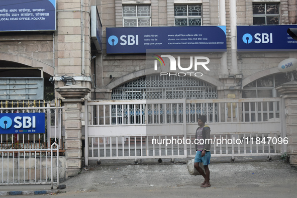 A person passes next to an SBI bank branch in Kolkata, India, on December 8, 2024. 