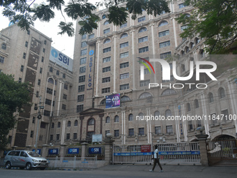 A person passes next to an SBI bank's local head office in Kolkata, India, on December 8, 2024. (