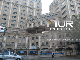 A person passes next to an SBI bank's local head office in Kolkata, India, on December 8, 2024. (