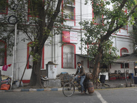 A person carries gas cylinders on his cycle while passing next to a foreign post office in Kolkata, India, on December 8, 2024. (