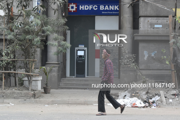 People pass next to HDFC Bank's ATM counter in Kolkata, India, on December 8, 2024. 