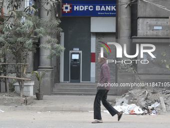 People pass next to HDFC Bank's ATM counter in Kolkata, India, on December 8, 2024. (